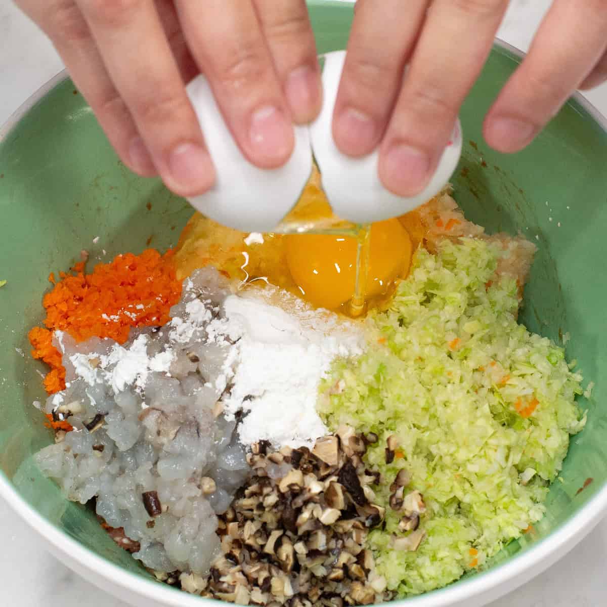 Added cornstarch and egg to the meat and vegetable mixture in the bowl.