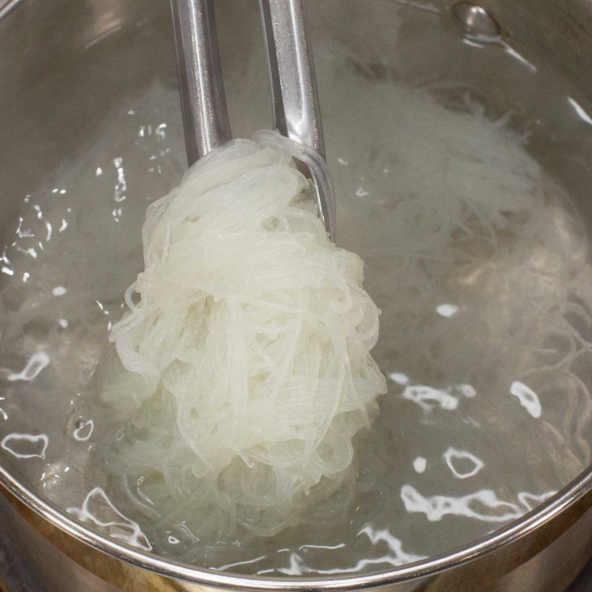 Blanching the noodles in the pot.