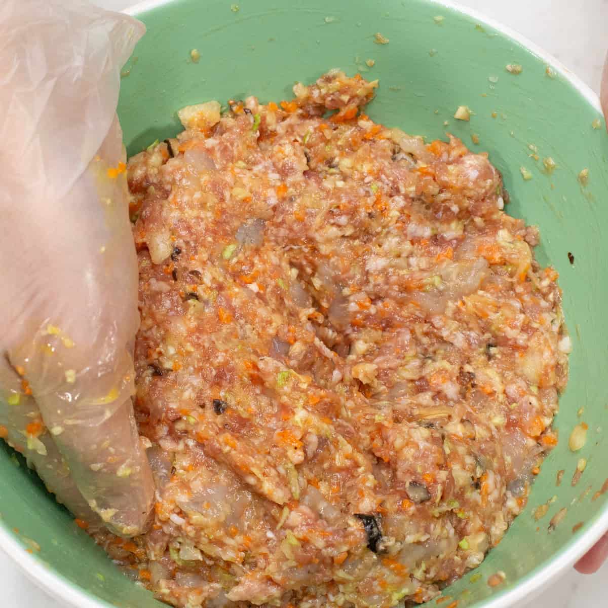 Combining the mixture in the bowl.
