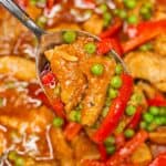 Pork guisantes pork and peas scooped by a spoon.