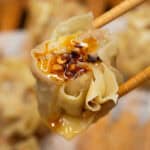 Pork with Shrimp Siomai topped with Garlic chili oil picked by a chopstick.
