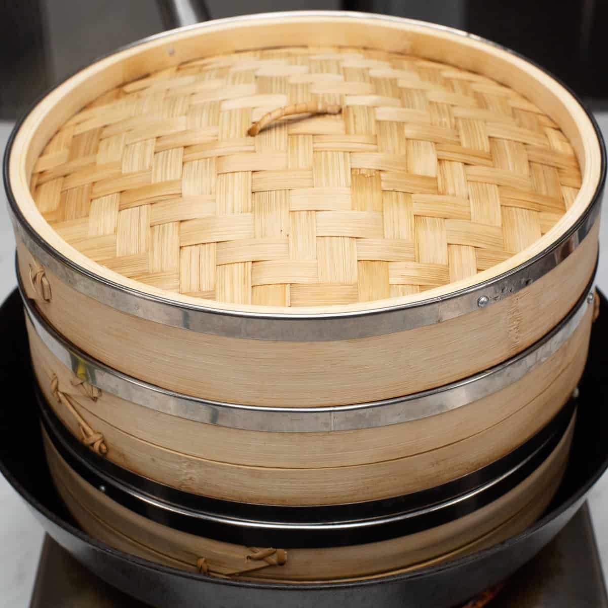 A steamer setup consisting of a large wok with steamer baskets inside.