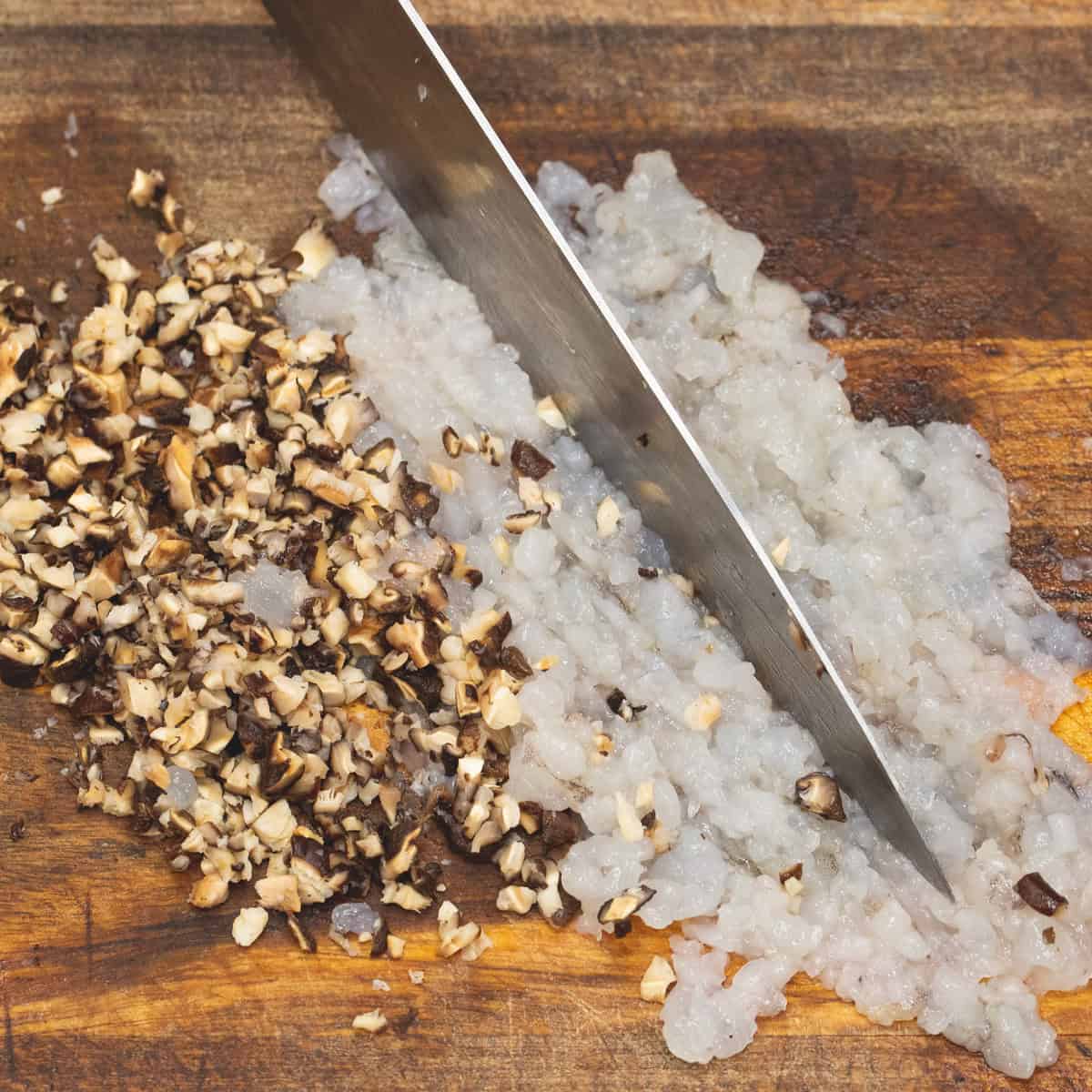 Finely chopping the shrimp and shiitake mushrooms. 