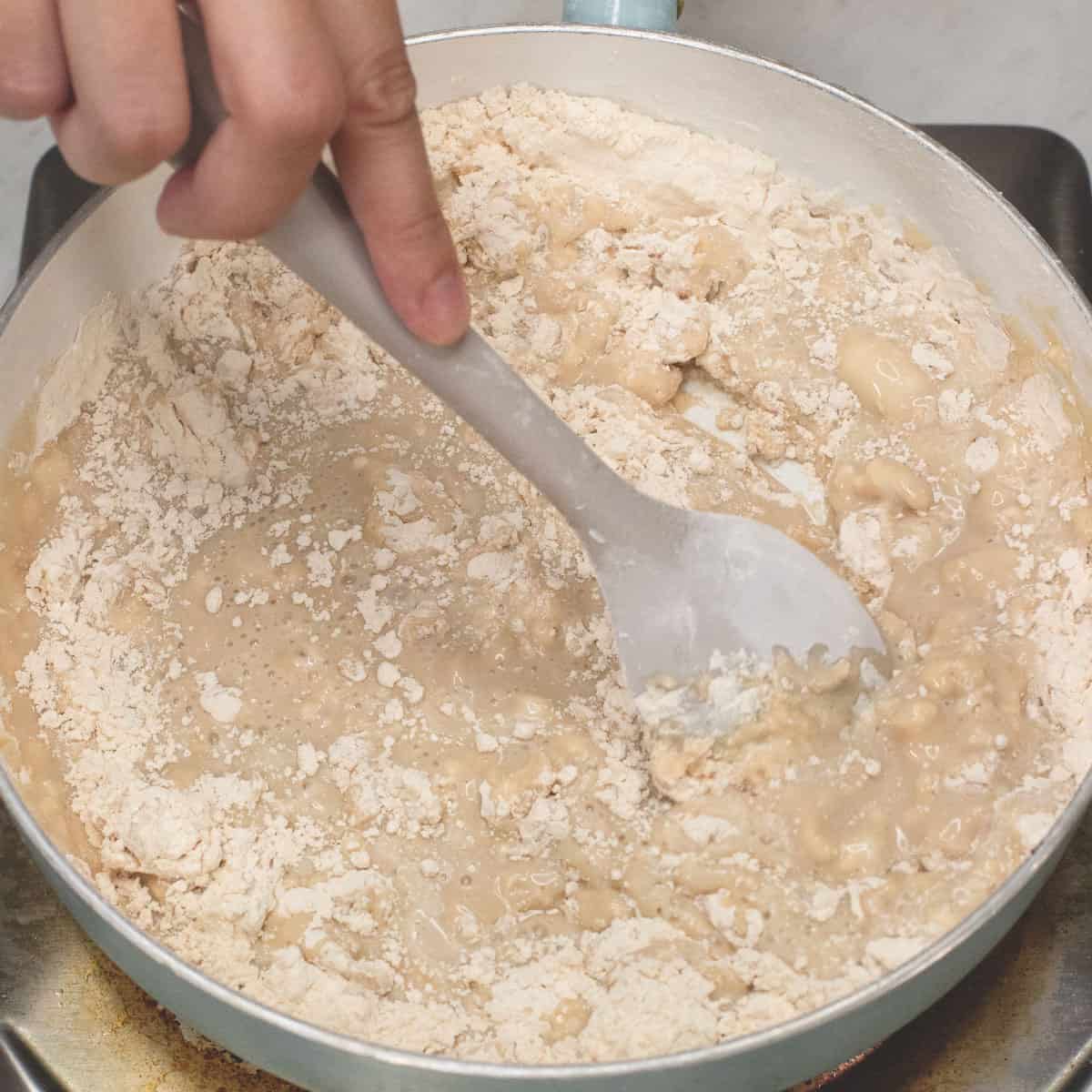Adding the coconut mixture and mixing it with the toasted glutinous rice four.