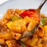 Sweet and sour fish scooped by a spoon.