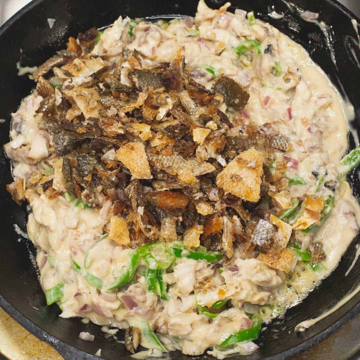 Added the crispy skin to the mixture in the skillet.