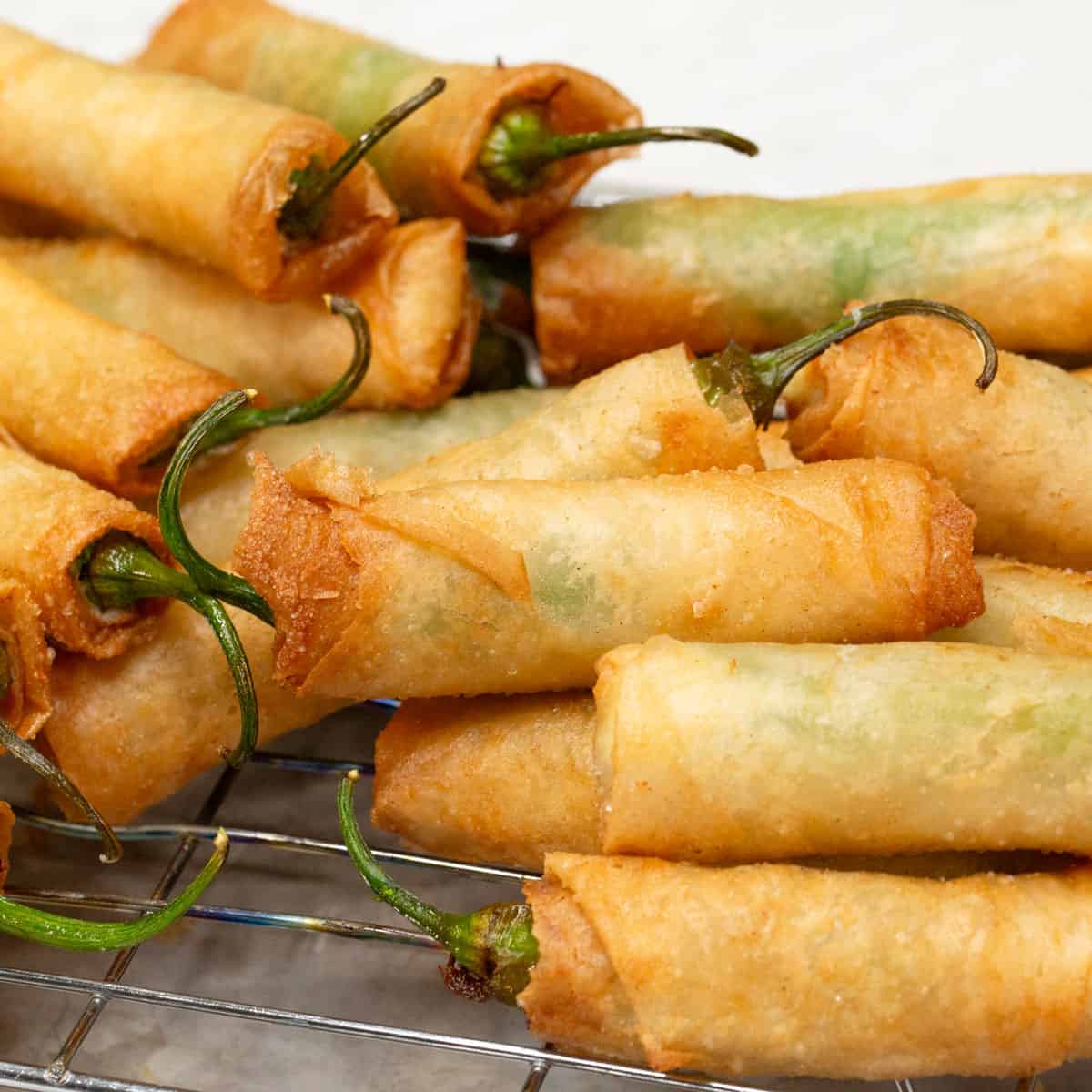Draining the fried lumpia on a wire rack.