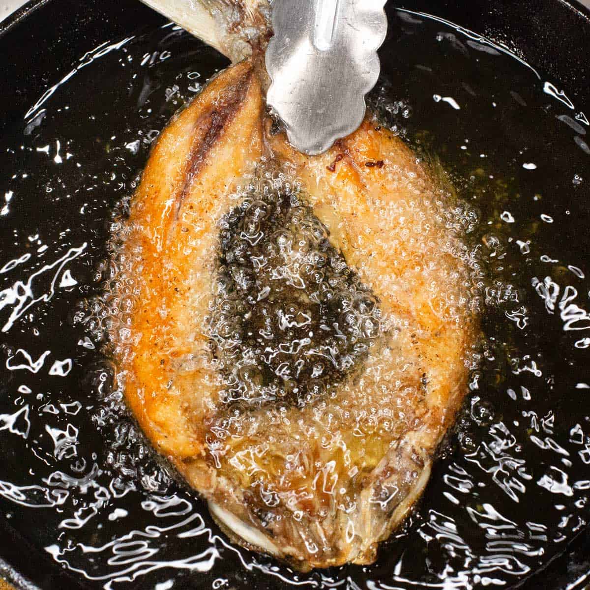 Frying the bangus in oil.