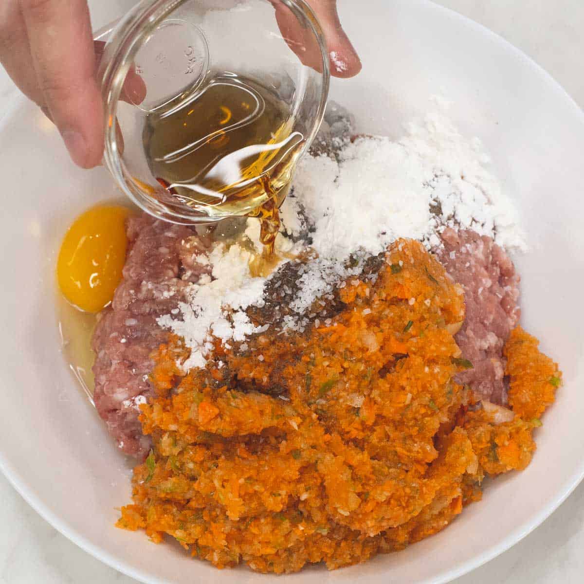 Combining the ingredients for the meatballs in the bowl