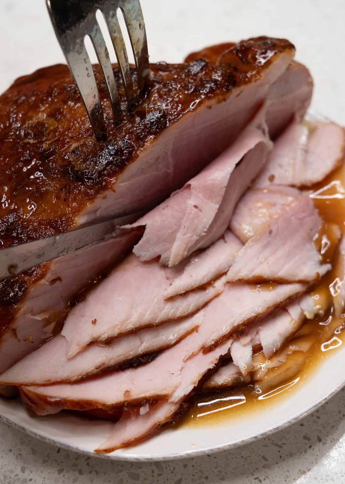 slicing boneless ham on a plate