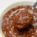 Filipino champorado in a bowl scooped by a spoon.