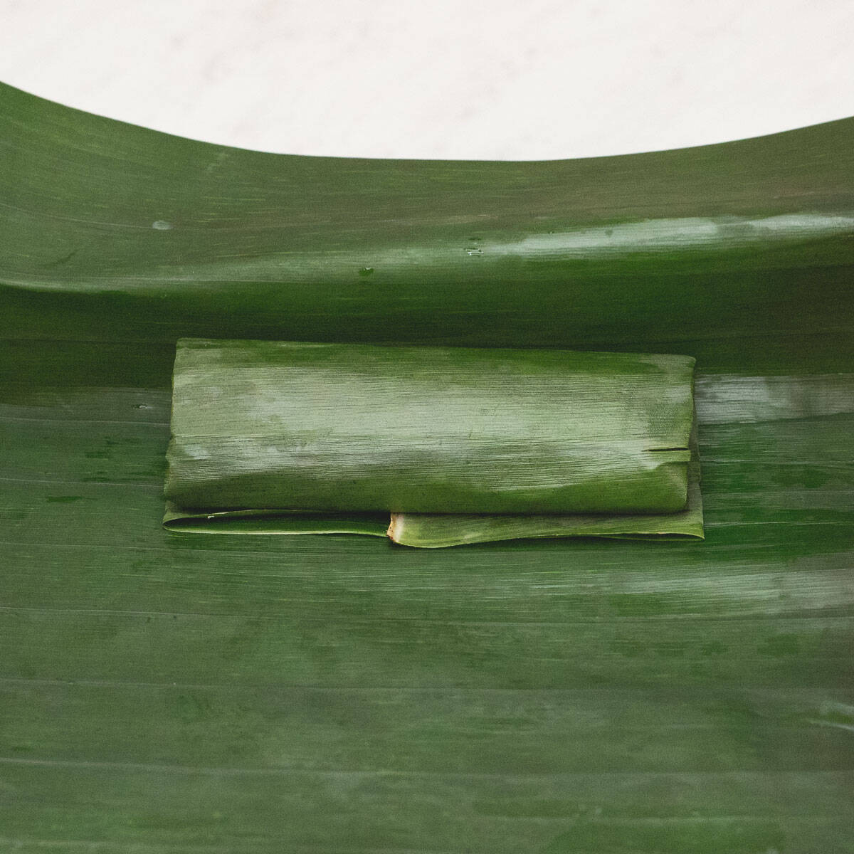 folding the larger leaf over the smaller leaf