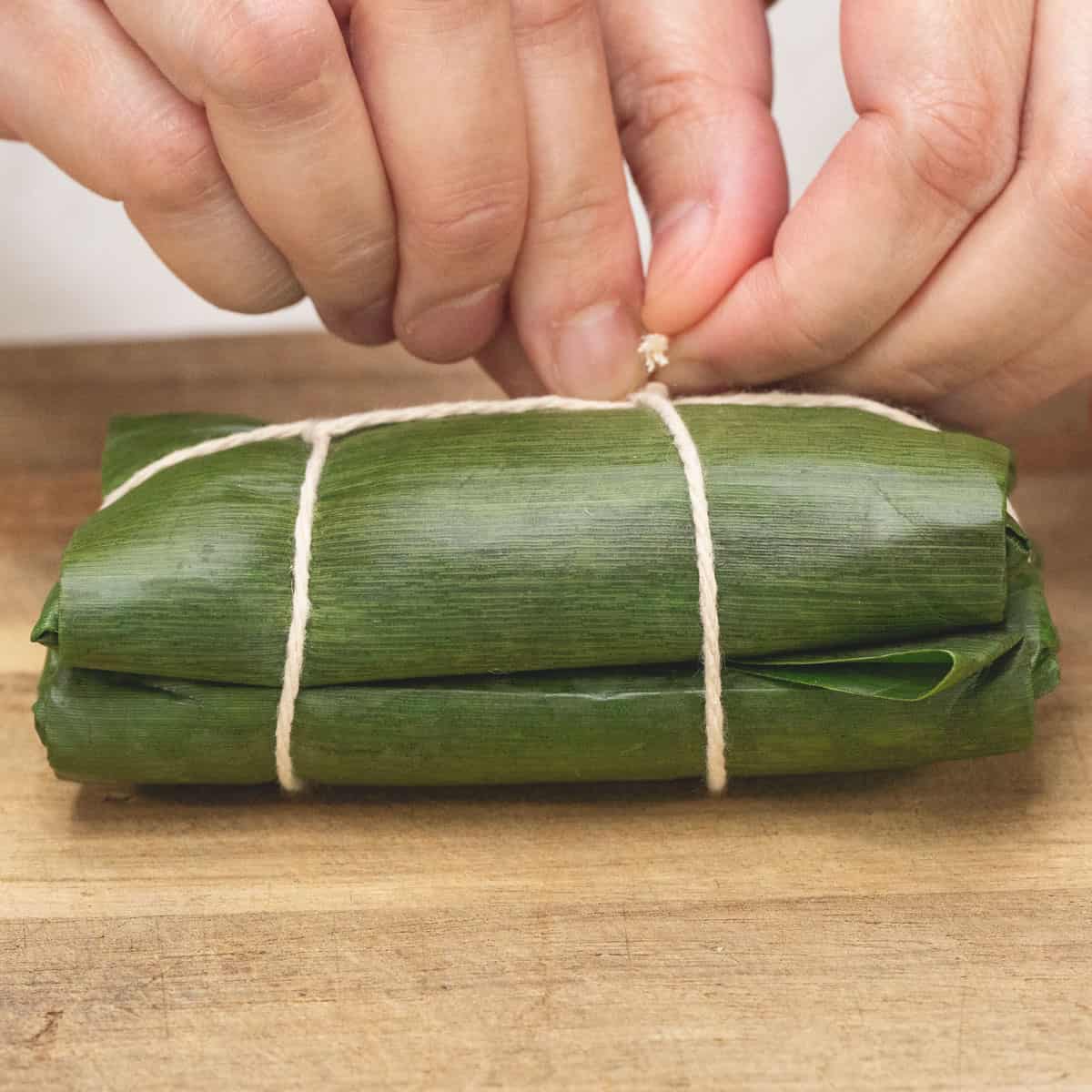 Double-wrapping the suman and tying them in pairs.