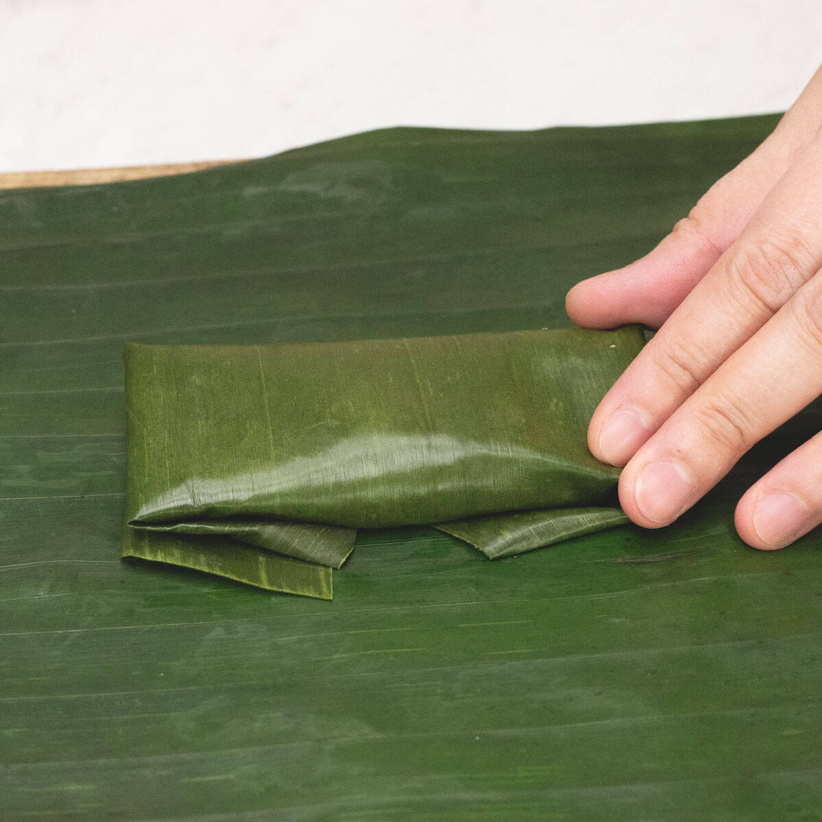 wrapping the banana leaf snugly