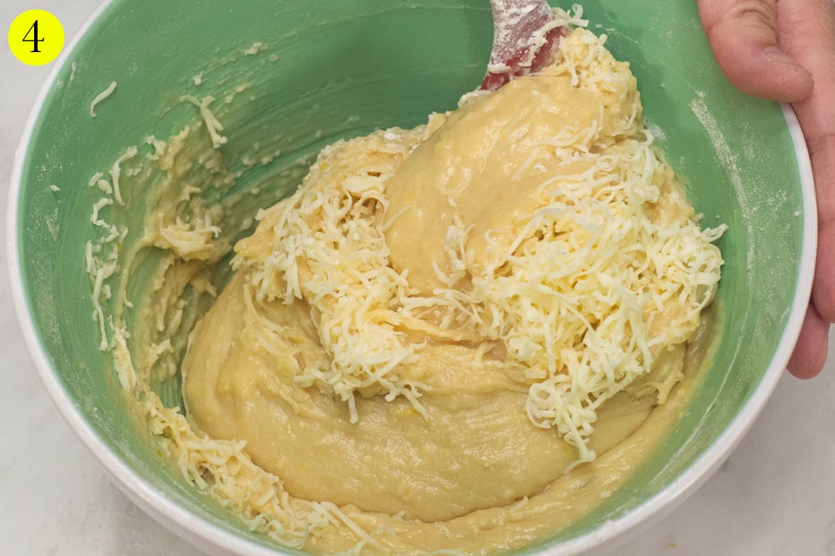Folding the cheese into the batter using a spatula.