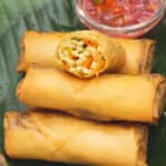Lumpiang Labong with a vinegar dipping sauce on a banana leaf.