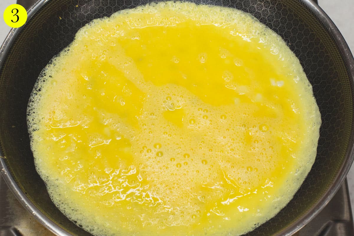 Frying the beaten eggs in a skillet.