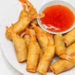 Shrimp Lumpia with sweet chill dipping sauce on a plate.