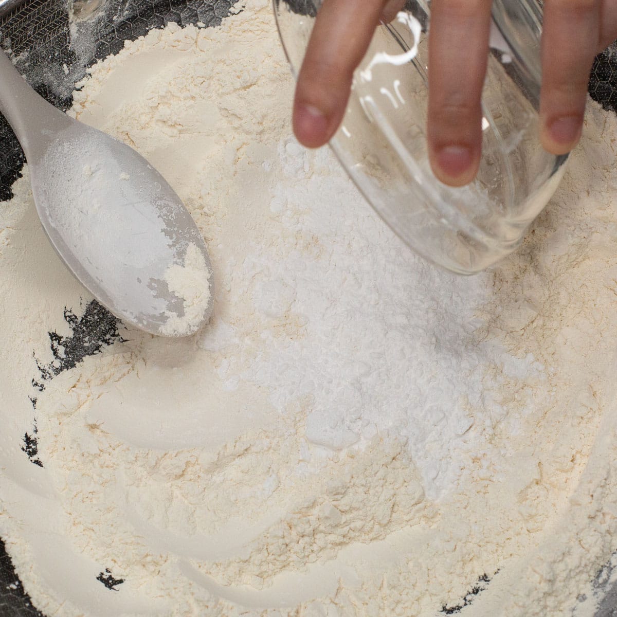 Adding tapioca flour to the toasted glutinous rice flour in the wok.