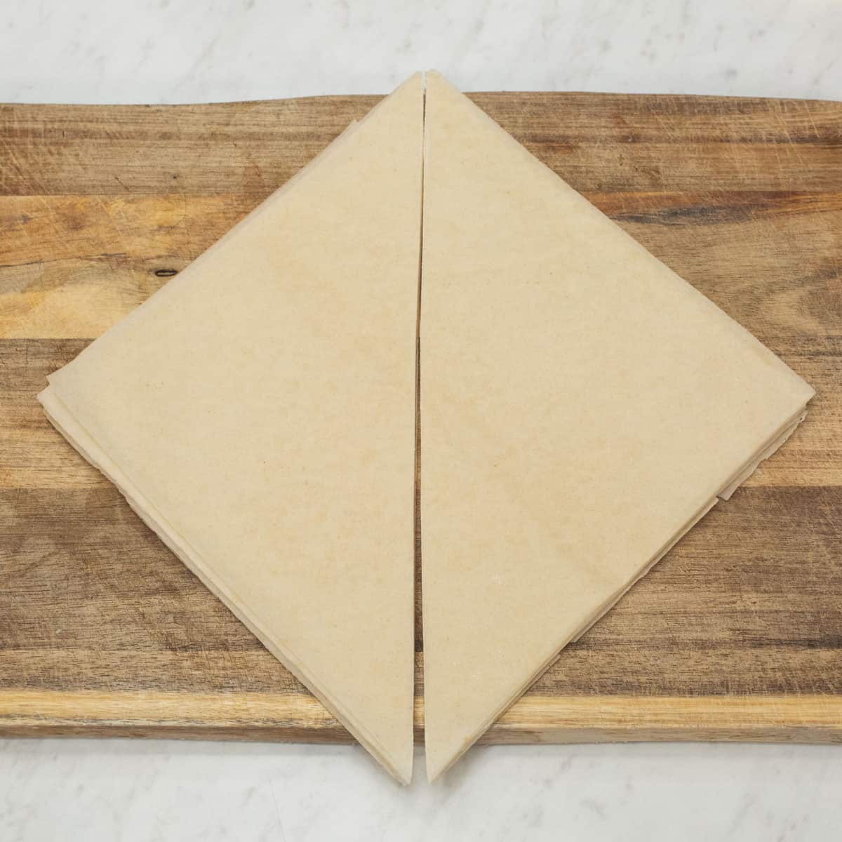 The spring roll wrapper cut in half diagonally