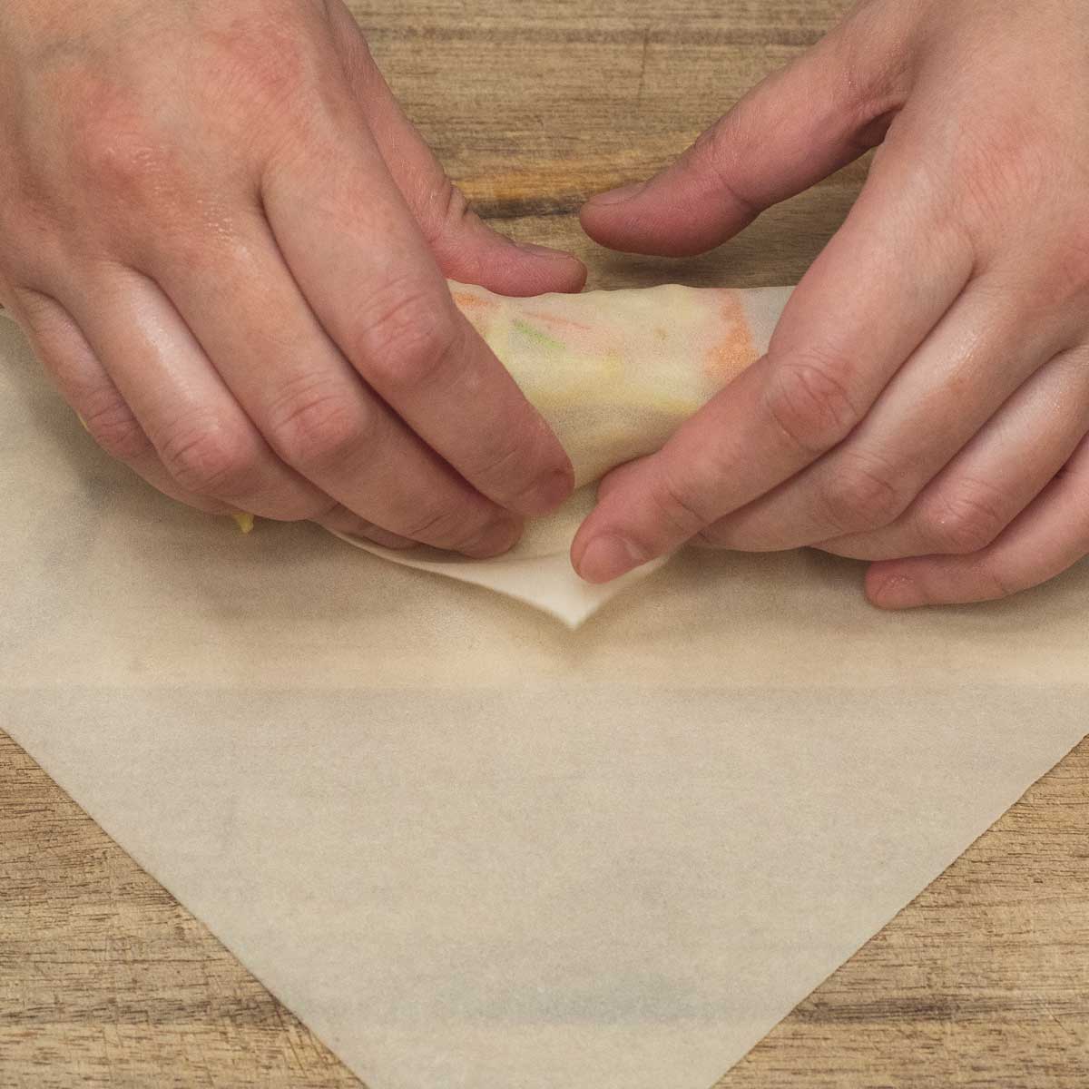 Folding the bottom wrapper over the filling.