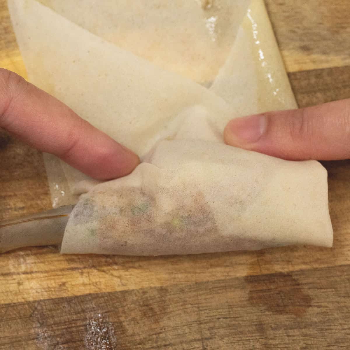 folding one side over the shrimp and meat filling