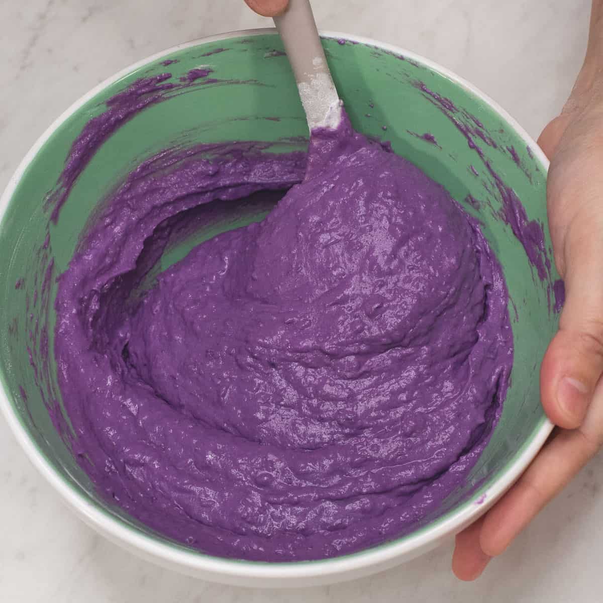 Combining all the ingredients in a bowl, then mixing them together.