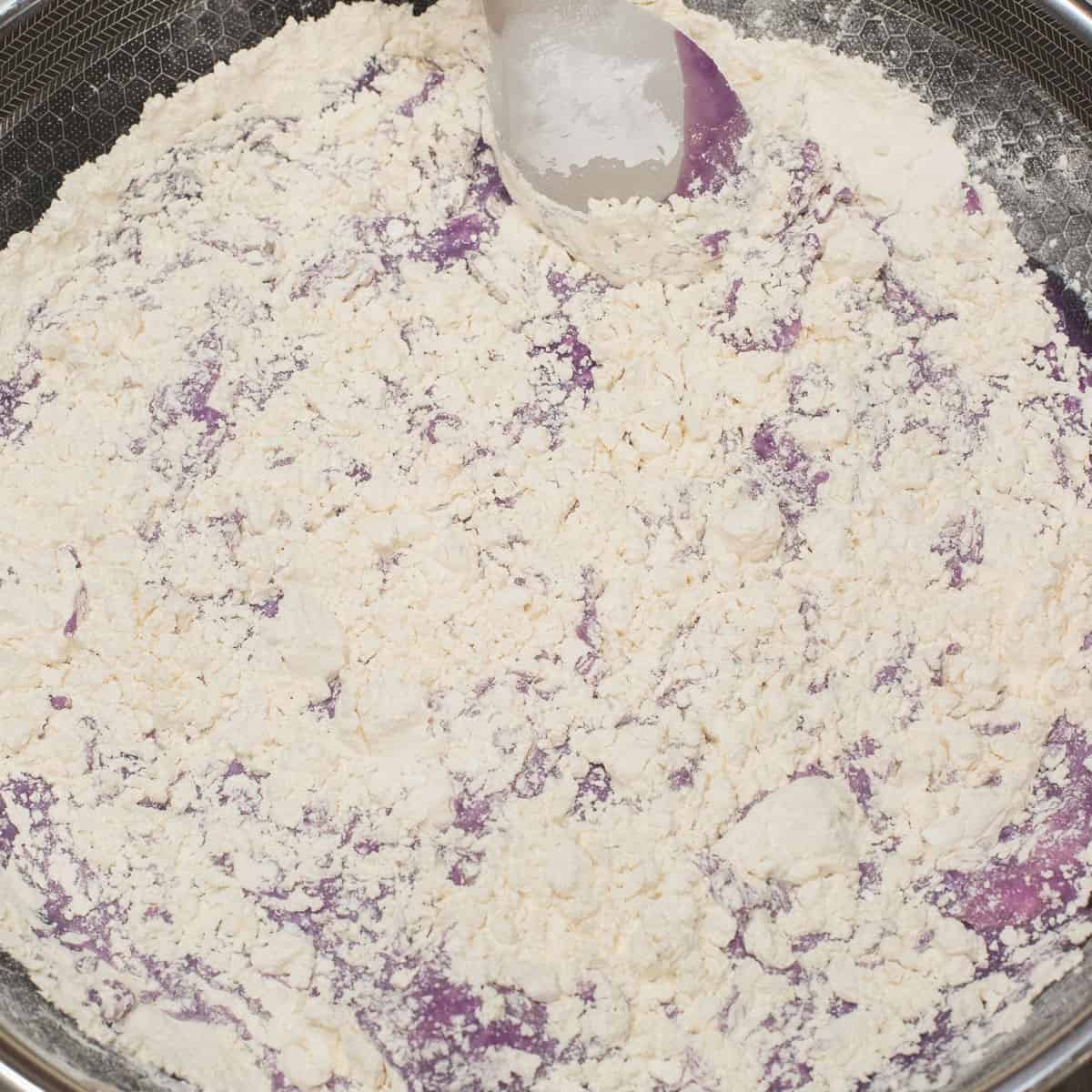 Mixing the wet and dry ingredients in the wok until thick