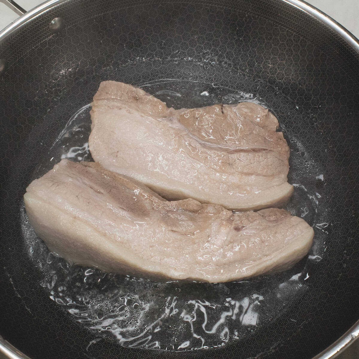 Parboiling the pork belly.