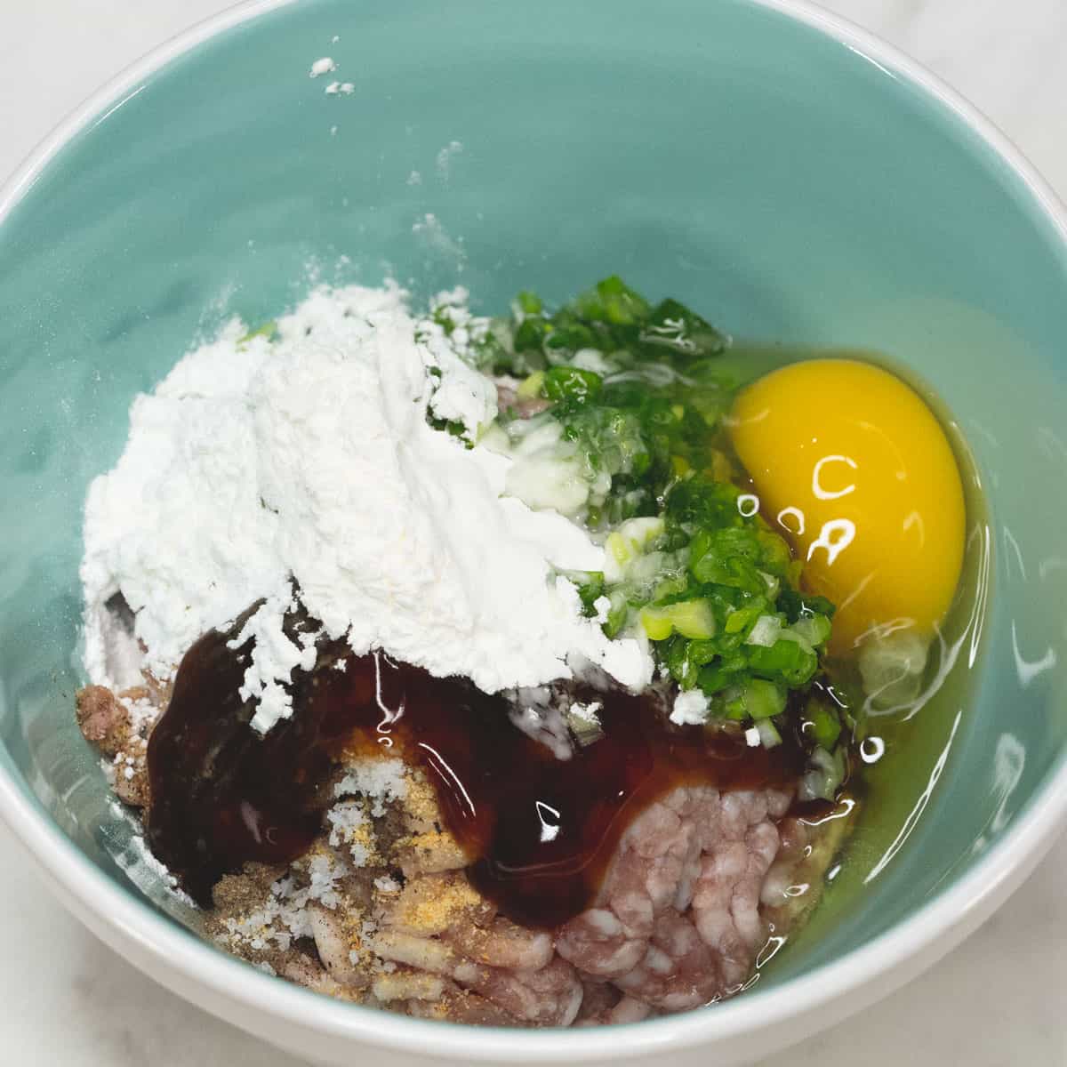 Mixing the meat mixture in a bowl.