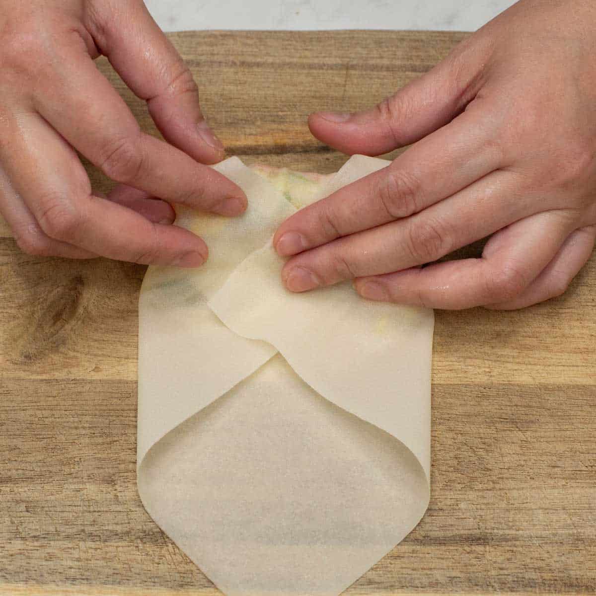 Folding in the sides to seal the filling.