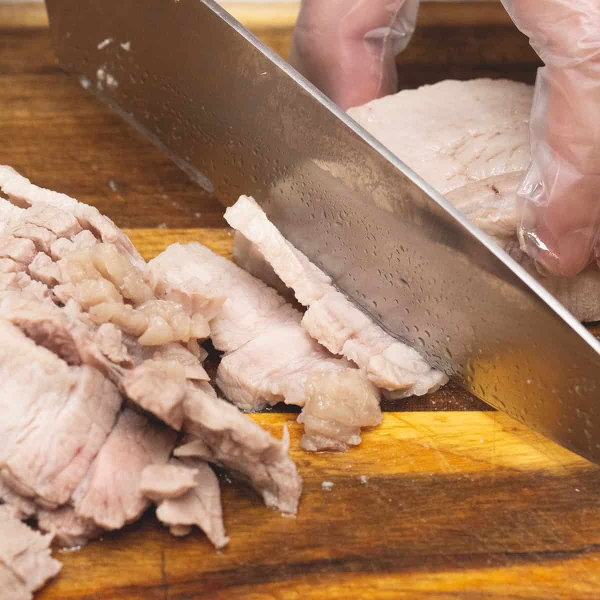 slicing the pork belly thinly.