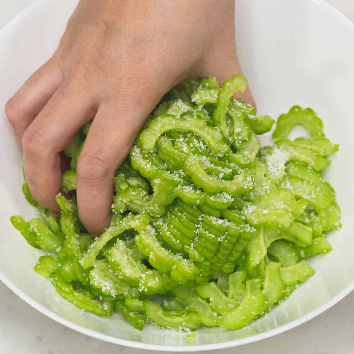 Massaging the ampalaya slices with salt