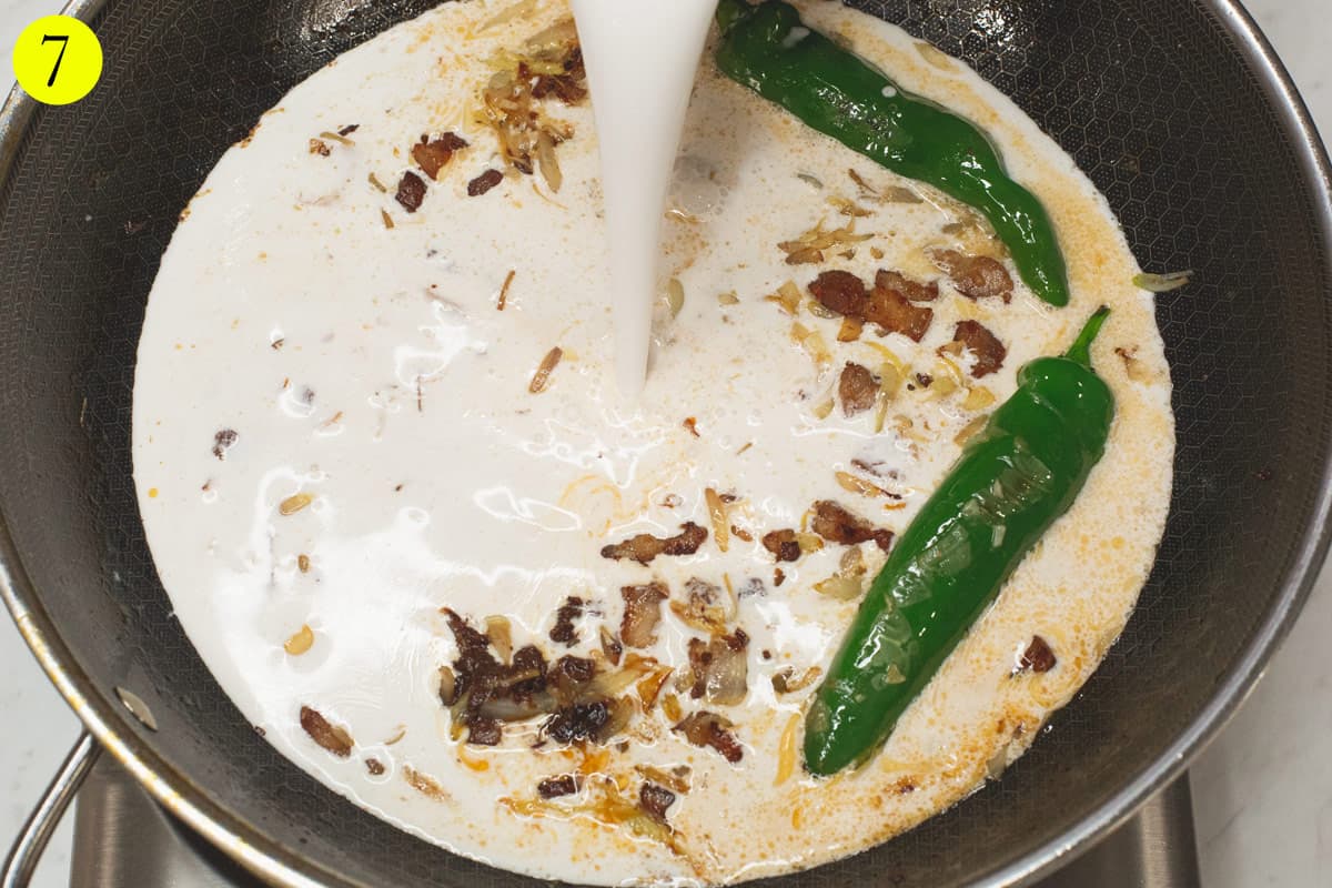 Adding the coconut milk into the wok.