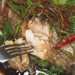 Steamed Fish with Ginger poked by a fork.