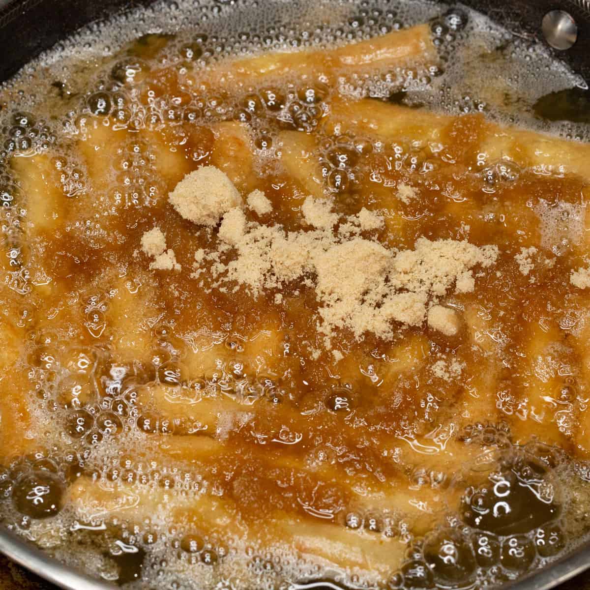 Frying Turones de Mani with brown sugar in the oil.