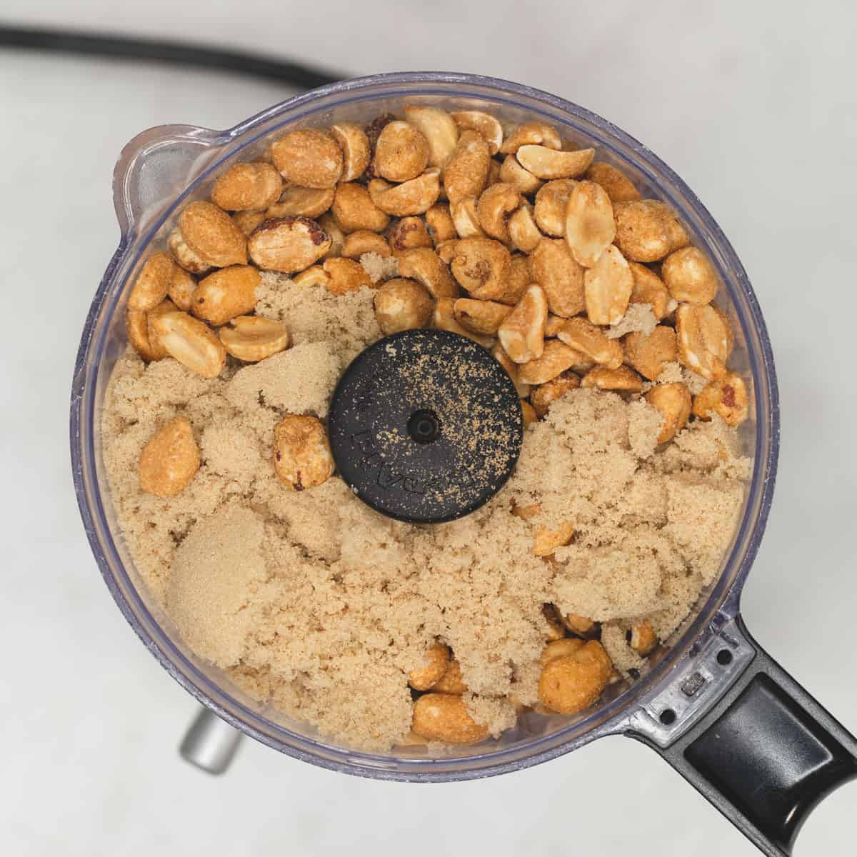 peanuts and sugar in a grinder