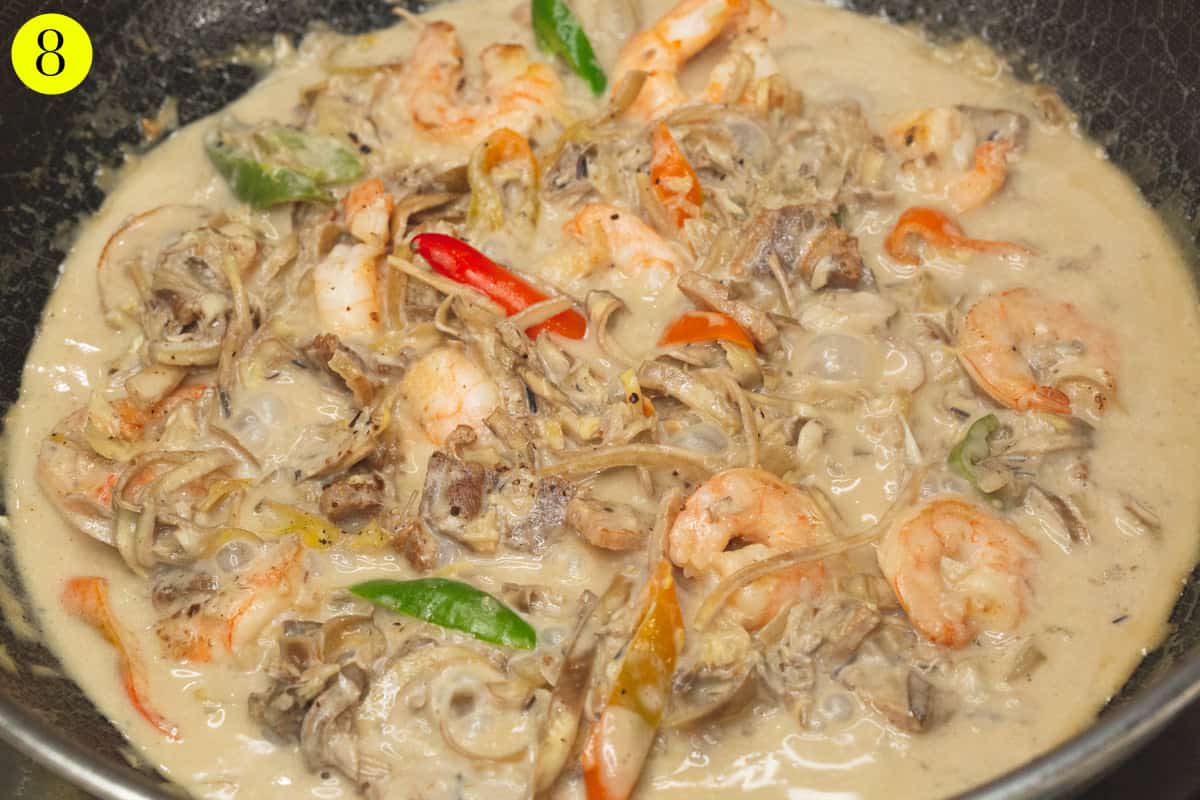 Added shrimp to the simmering mixture in the wok.