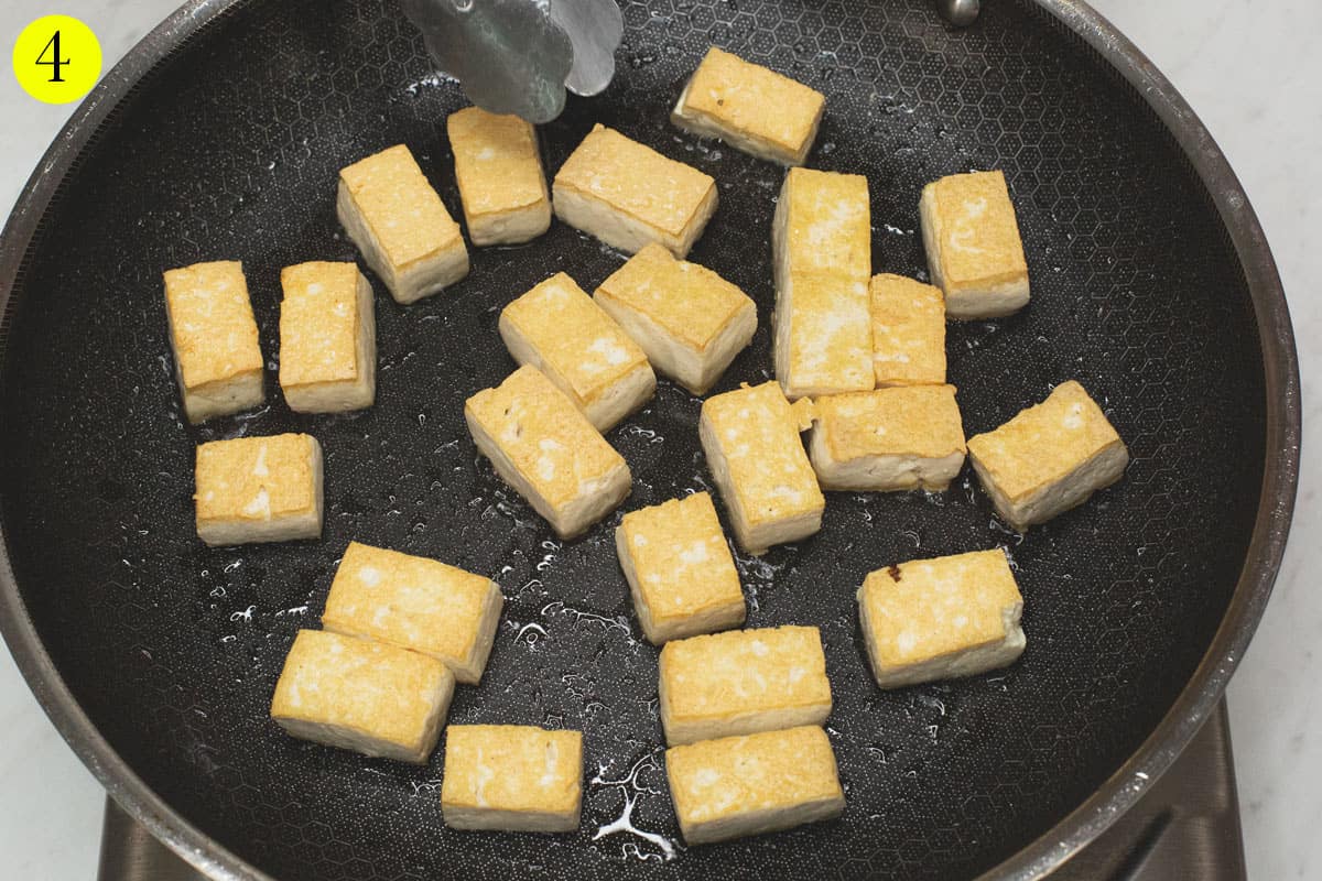 Frying the tofu pieces in a skillet.
