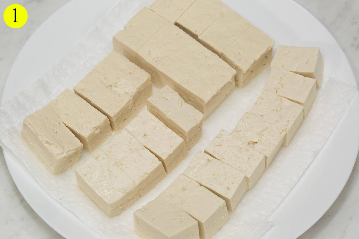 Cut up tofu draining on paper towels.