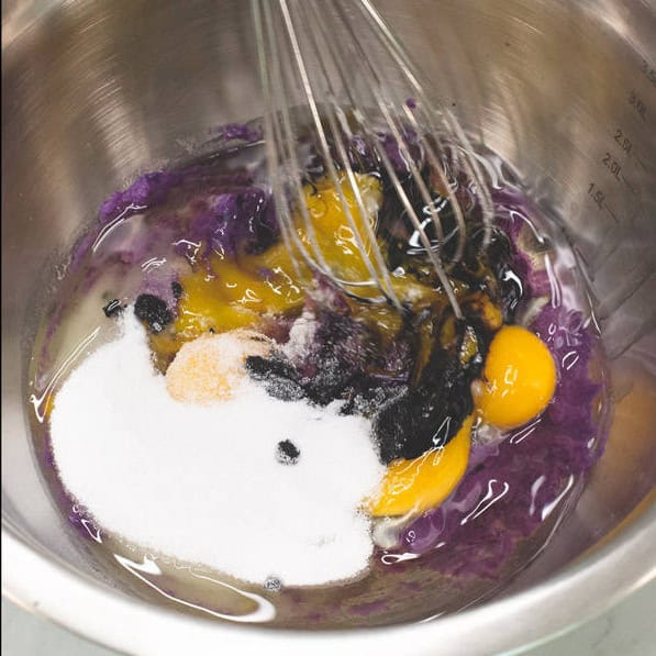 Adding the other wet ingredients to the mashed ube.