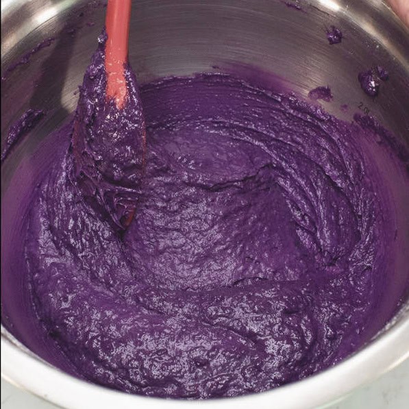 Mixing the dry ingredients into the purple ube batter.