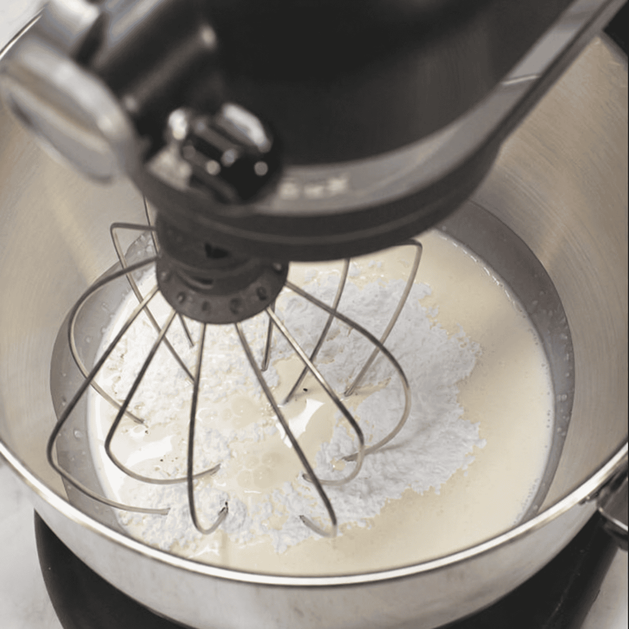 Heavy cream, powdered sugar, and vanilla in the mixer bowl.