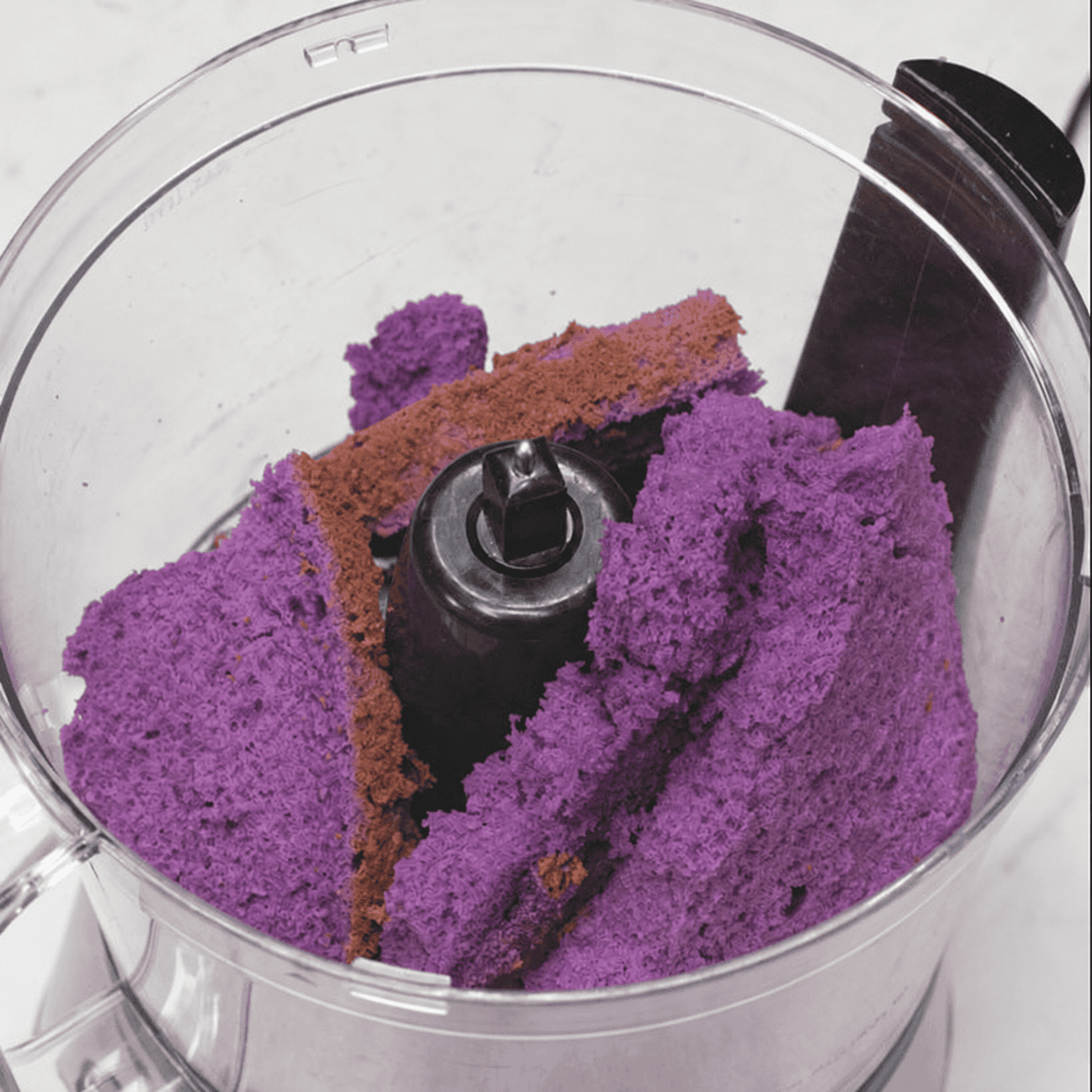 Pieces of ube cake in the food processor.