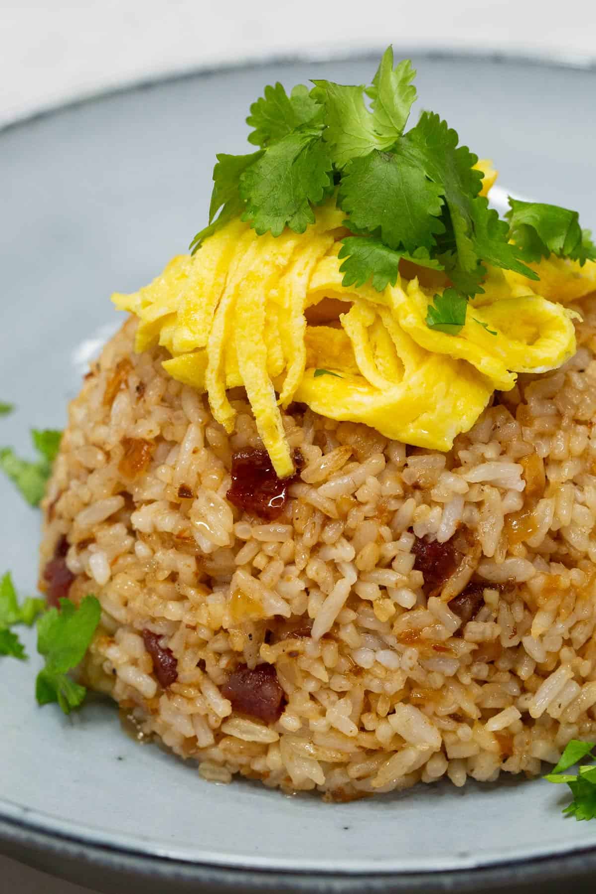 Bagoong Fried Rice topped with scrambled eggs on a plate.