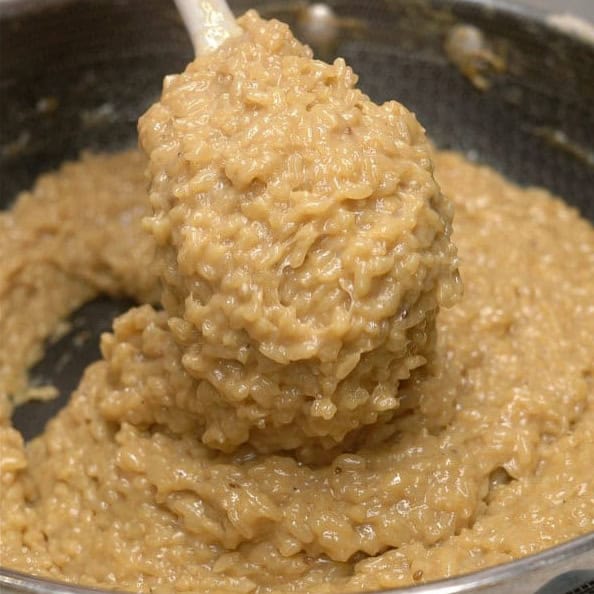 Thick and sticky biko mixture lifted with a spatula.