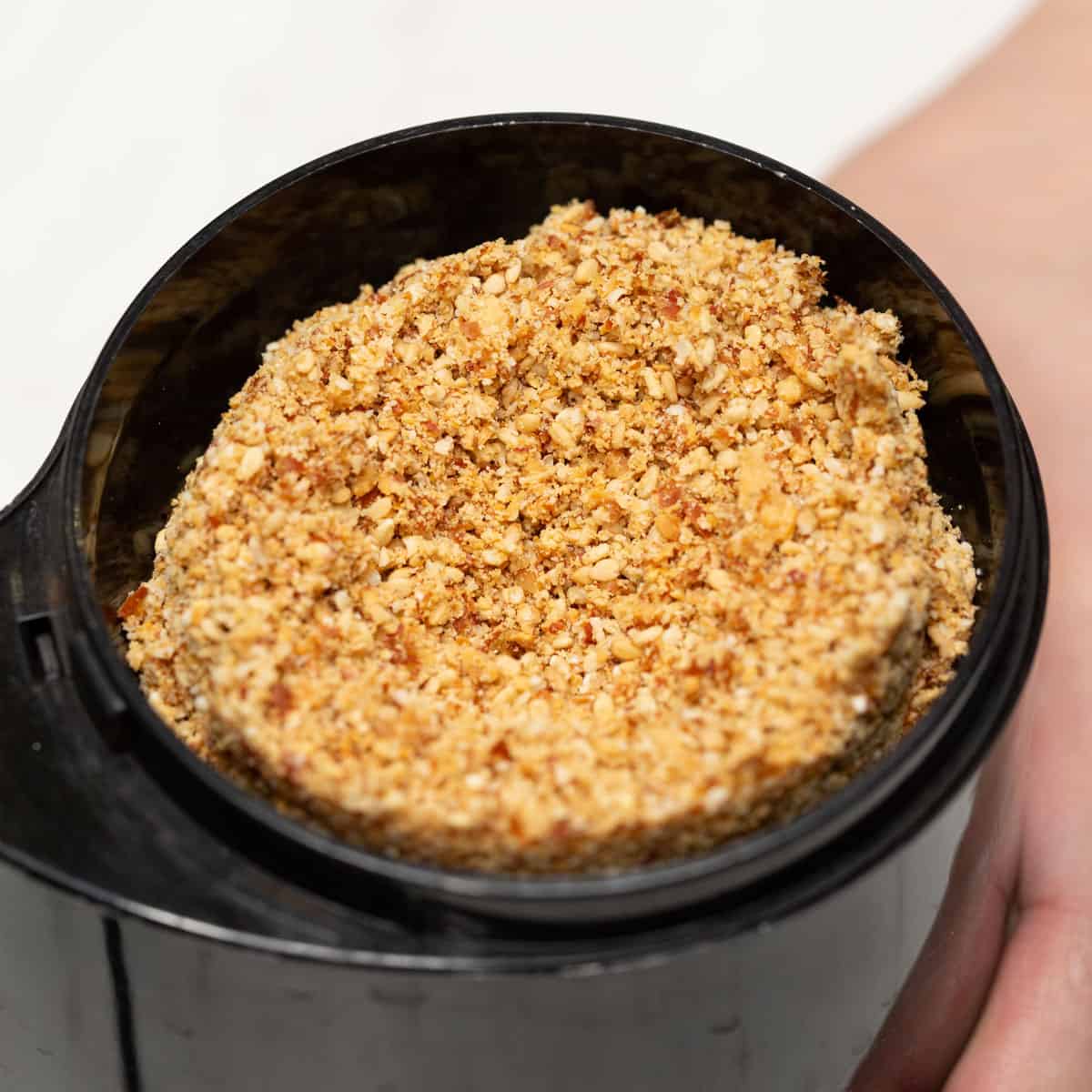 Combined peanuts and sesame seeds in a coffee grinder, then grinding them until fine.
