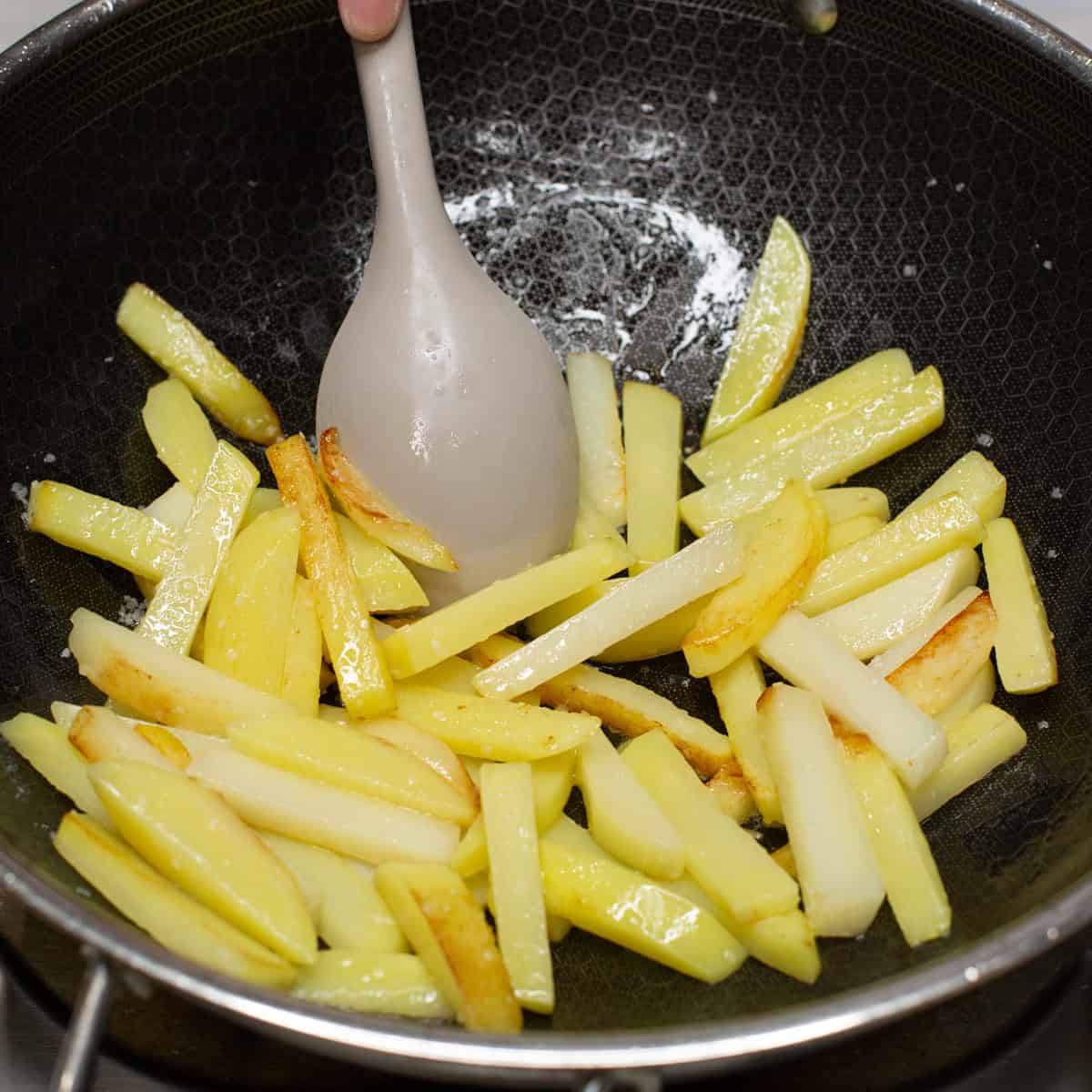 sauteing potatoes in a wok