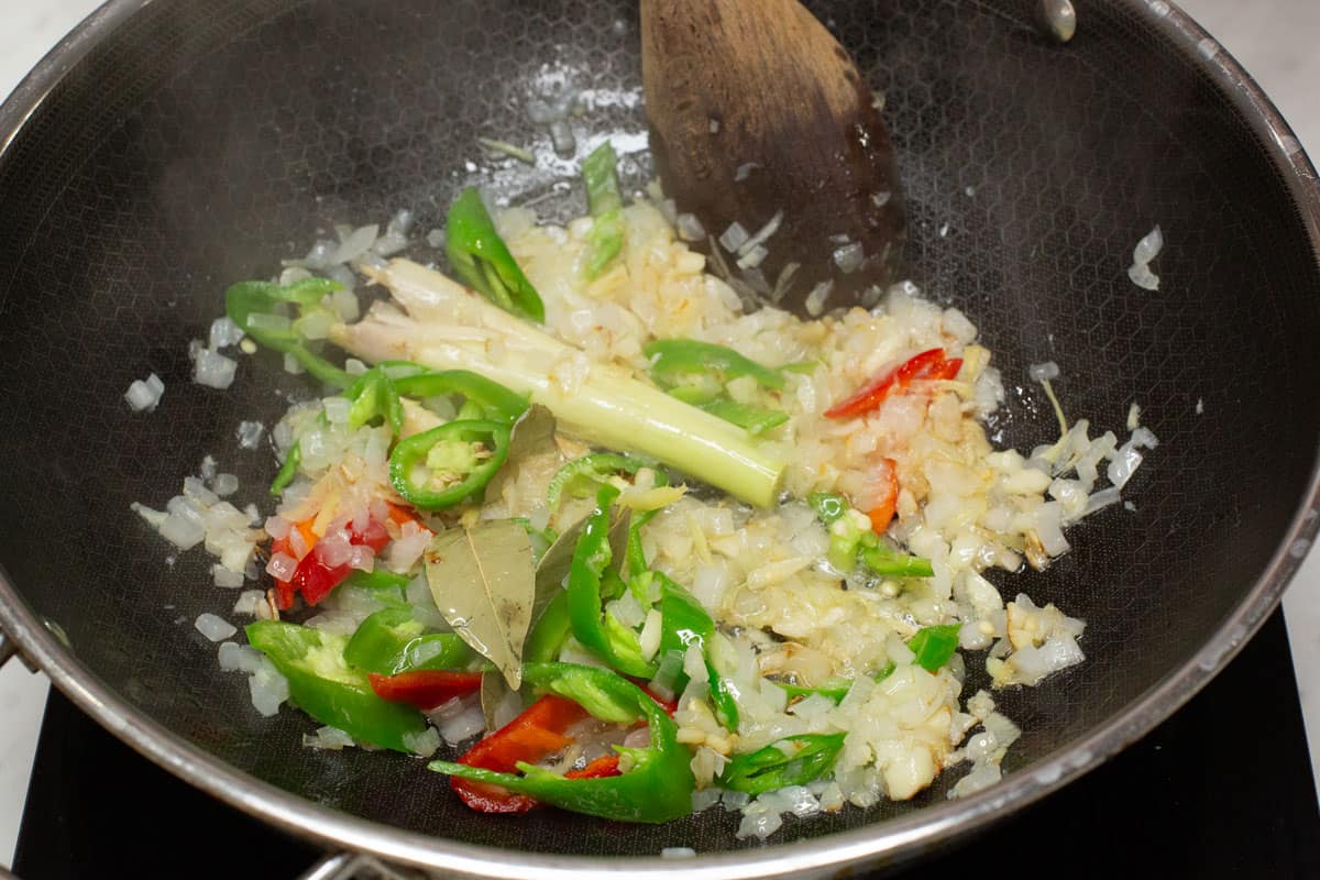 Sauteing aromatics with plenty of chilies in a wok.