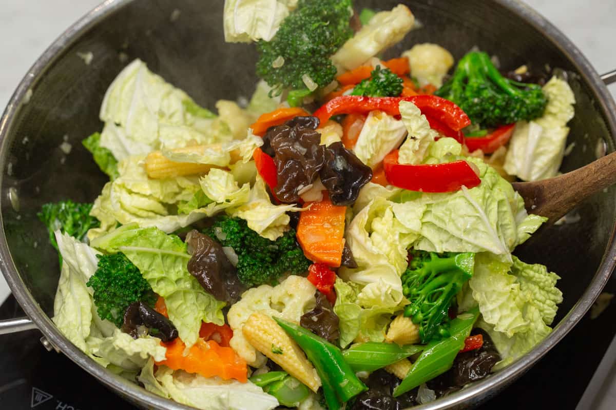 Stir-fying all the vegetables in the wok.